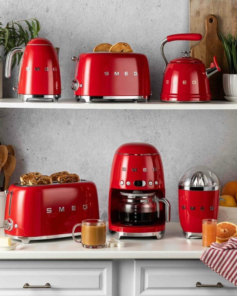 Red SMEG toaster, coffee machine and citrus juicer on a kitchen counter